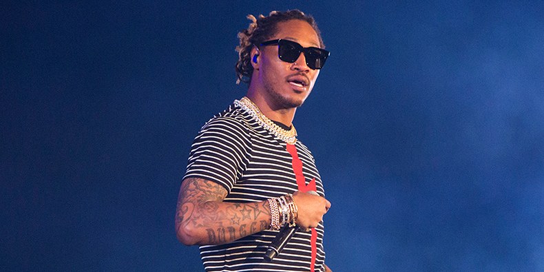 Future is wearing a striped black and white shirt with a red mark down the middle. Future has on black sunglasses.